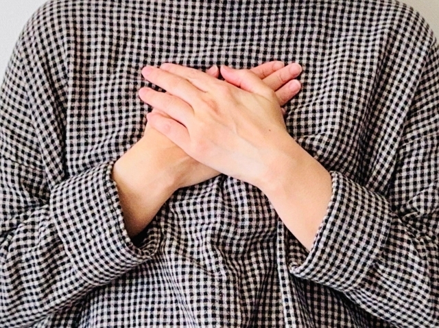 胸に両手をあててる人